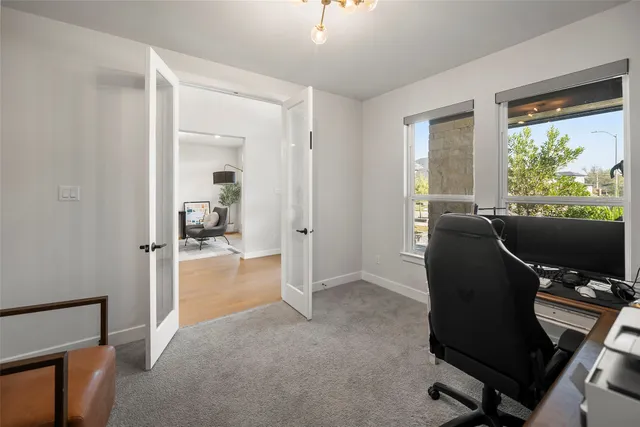 a view of a workspace with furniture and a window