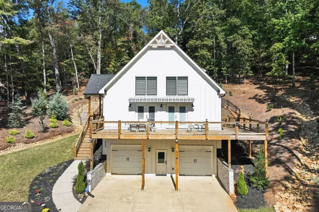 a view of a white house with a yard patio and furniture
