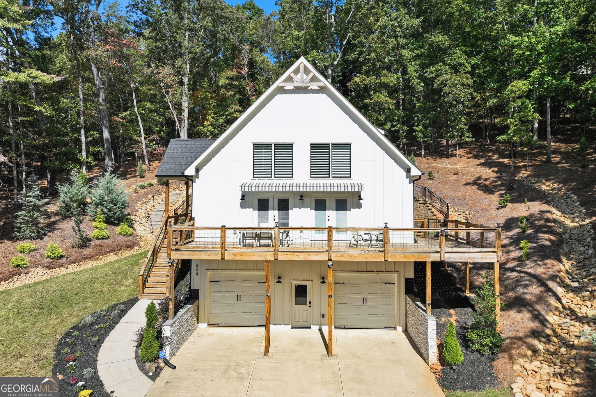 a view of a white house with a yard patio and furniture