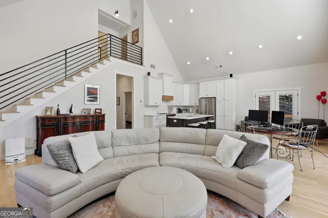 a living room with furniture kitchen view and a chandelier