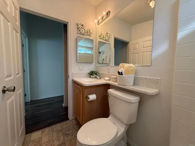 a bathroom with a toilet sink vanity and mirror