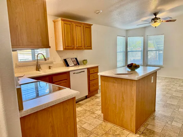 a kitchen with stainless steel appliances a sink cabinets and a window