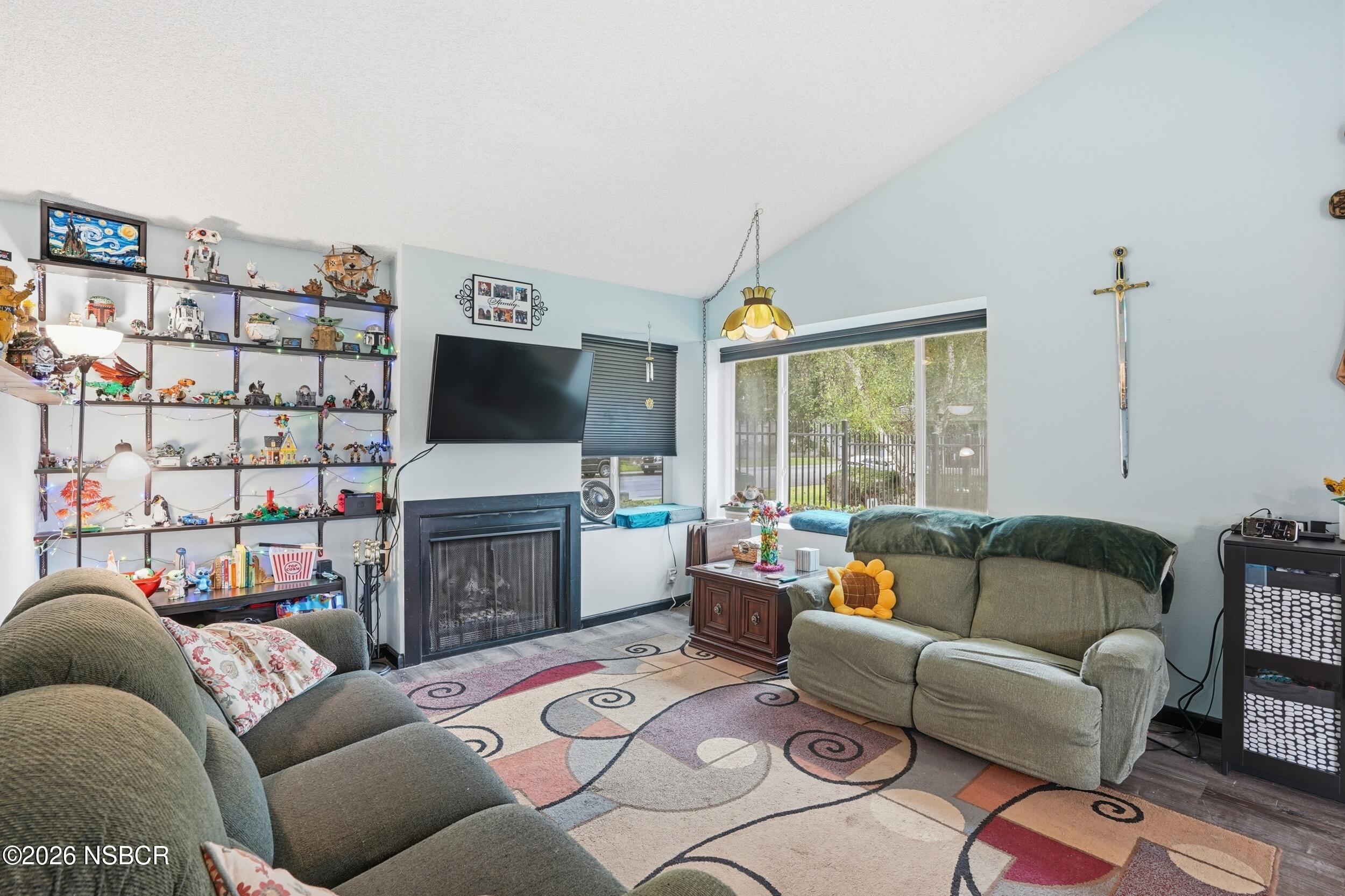 218 North R Street Lompoc, CA 93436 - Photo 8 of 24 a living room with furniture a flat screen tv and a floor to ceiling window