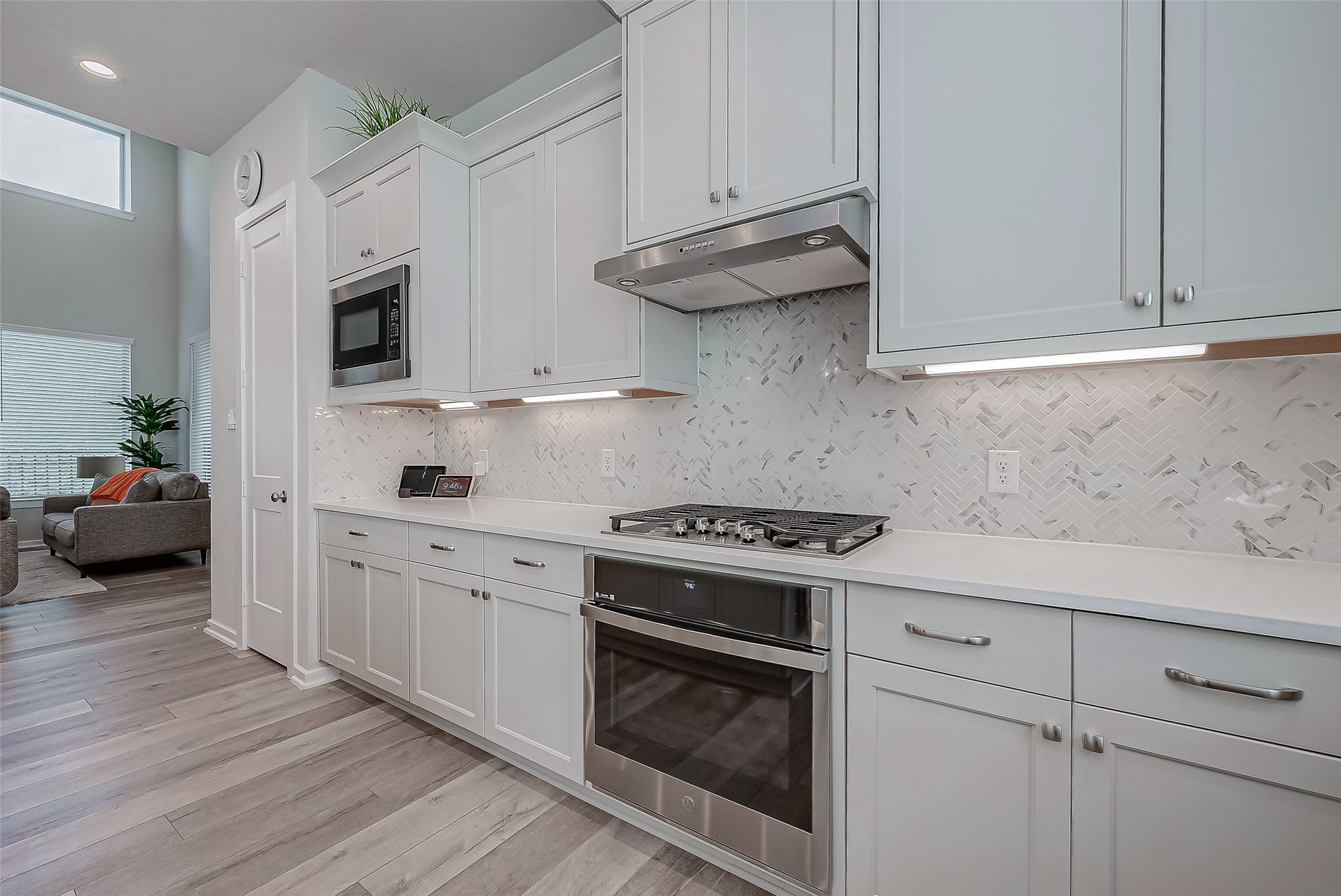a kitchen with stainless steel appliances white cabinets and a stove top oven