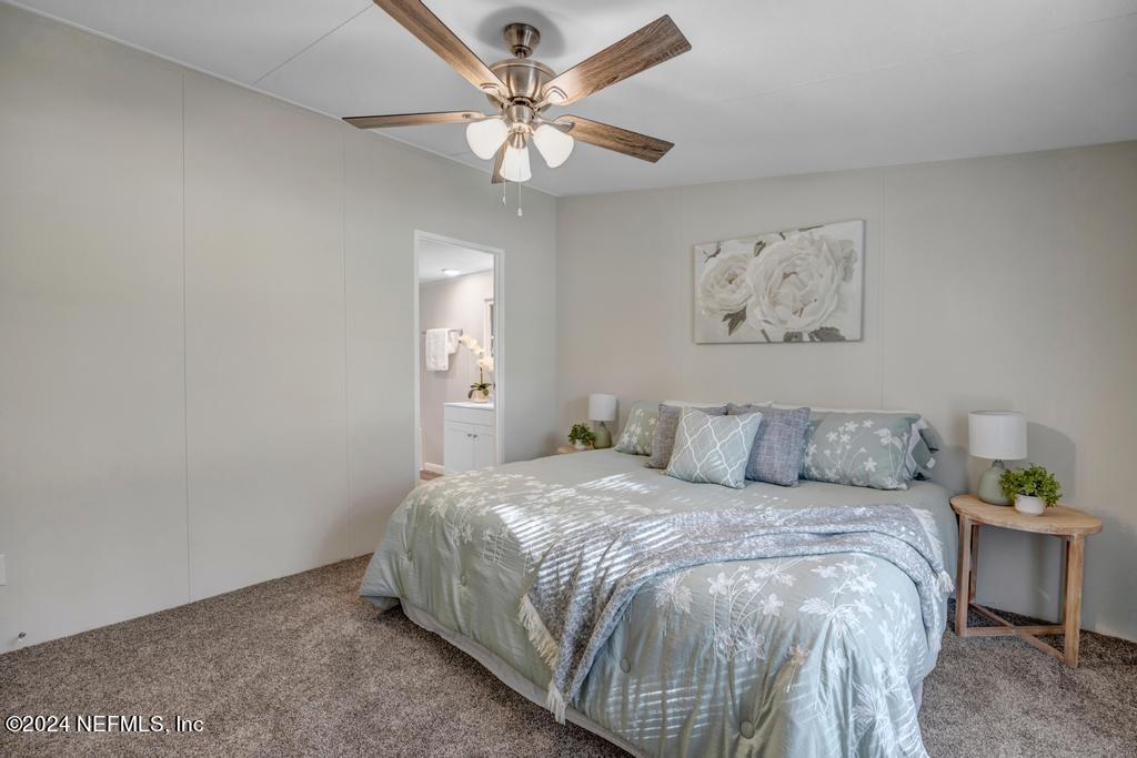 5557 Acadia Street Keystone Heights, FL 32656 - Photo 18 of 32 a bedroom with a bed and a chandelier