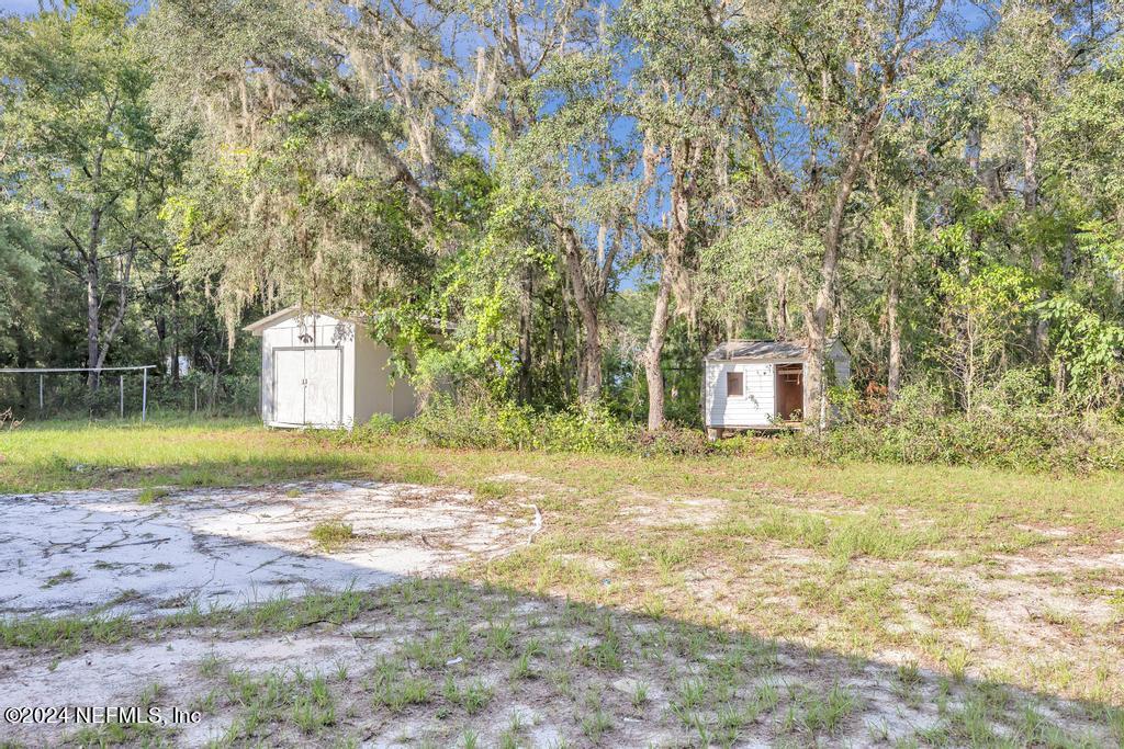 5557 Acadia Street Keystone Heights, FL 32656 - Photo 32 of 32 a view of a swimming pool with a yard and large trees
