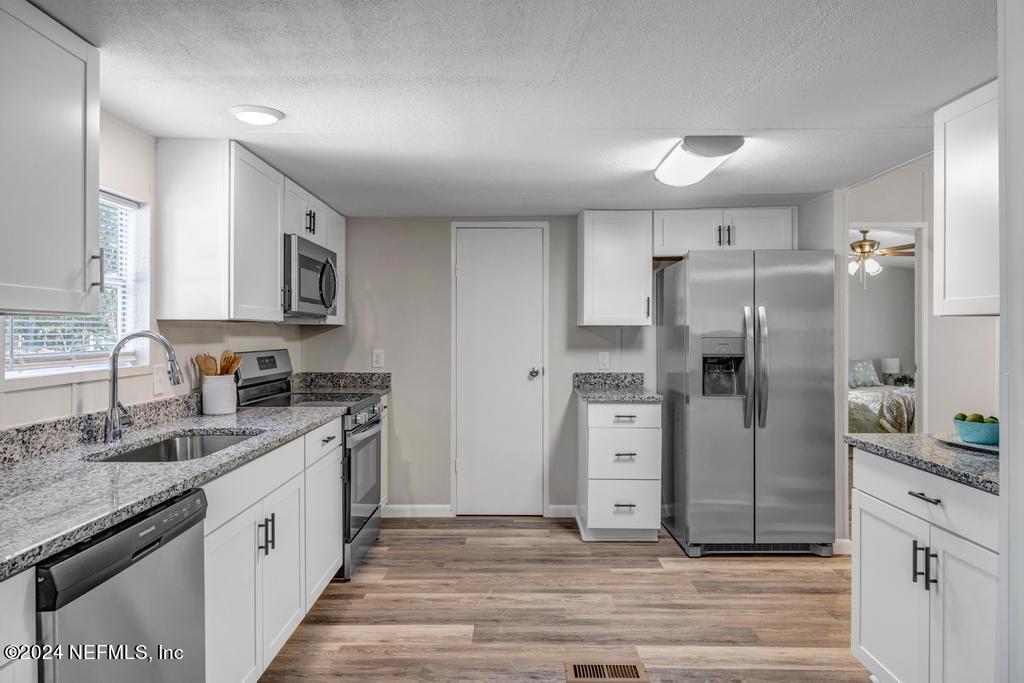 5557 Acadia Street Keystone Heights, FL 32656 - Photo 6 of 32 a kitchen with stainless steel appliances granite countertop a refrigerator and a stove top oven