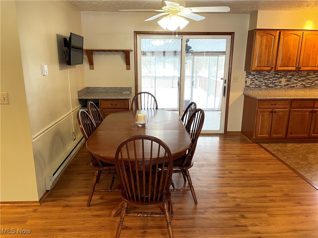 1381 Robb Road Conneaut, OH 44030 - Photo 11 of 50 Dining area with a baseboard radiator, light wood-style floors, a textured ceiling, and a ceiling fan