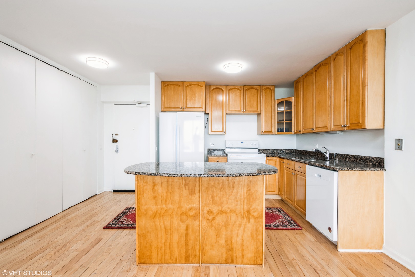 5415 North Sheridan Road, Unit 1504 Chicago, IL 60640 - Photo 5 of 21 a kitchen with granite countertop wooden cabinets a sink and dishwasher