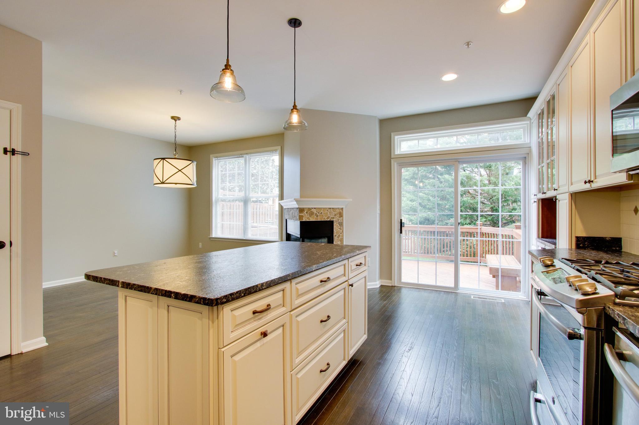 8818 Howard Forest Lane Baltimore, MD 21208 - Photo 12 of 31 a kitchen with stainless steel appliances granite countertop a stove a sink and a flat screen tv