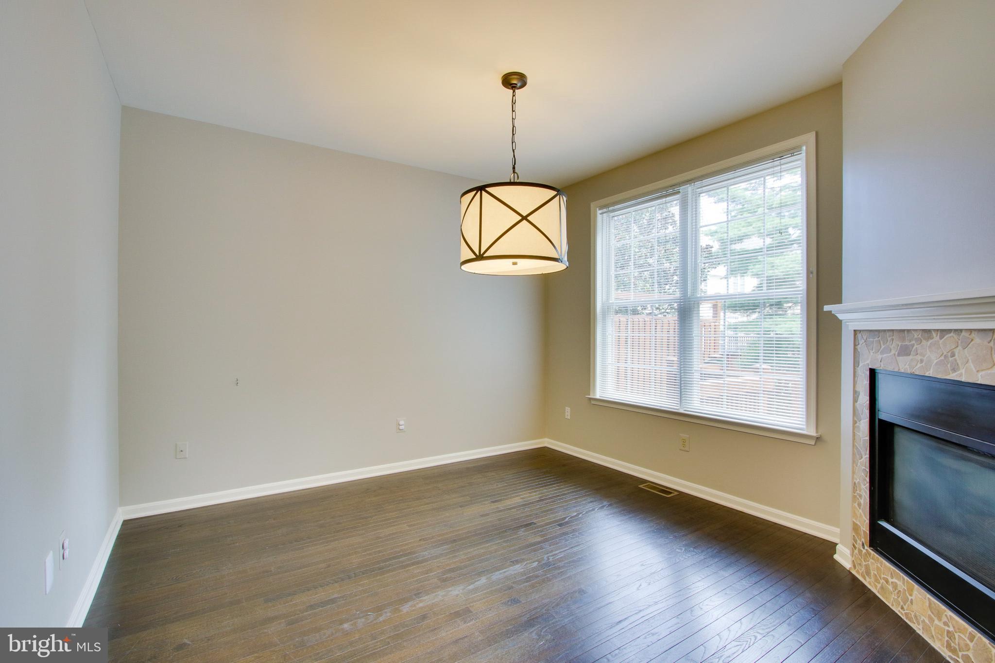8818 Howard Forest Lane Baltimore, MD 21208 - Photo 13 of 31 a view of a room with wooden floor fireplace and windows
