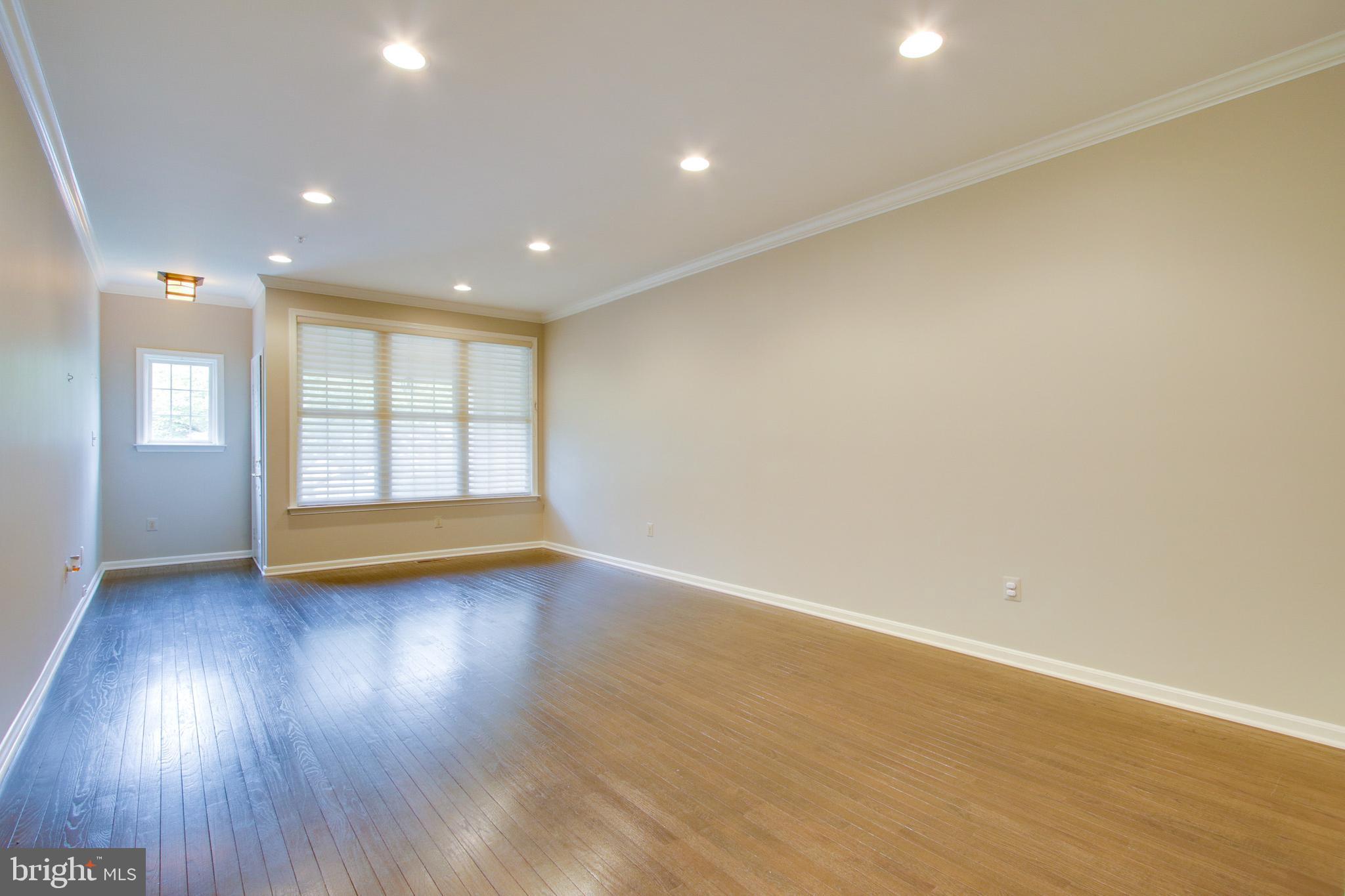 8818 Howard Forest Lane Baltimore, MD 21208 - Photo 2 of 31 a view of empty room with wooden floor and fan