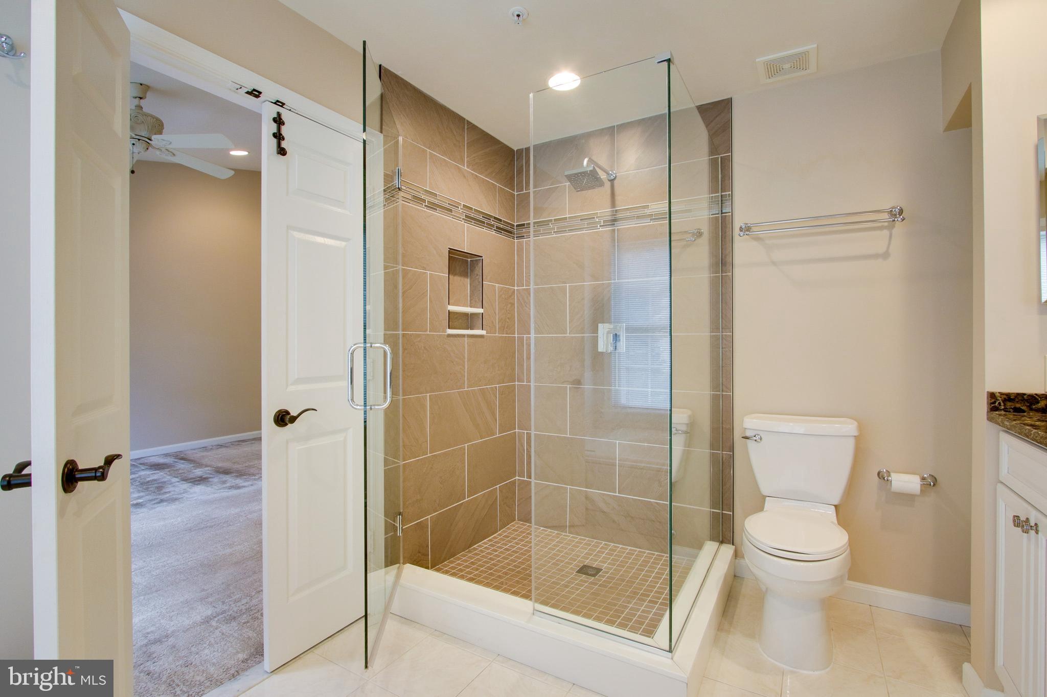 8818 Howard Forest Lane Baltimore, MD 21208 - Photo 22 of 31 a bathroom with a shower a toilet and a sink