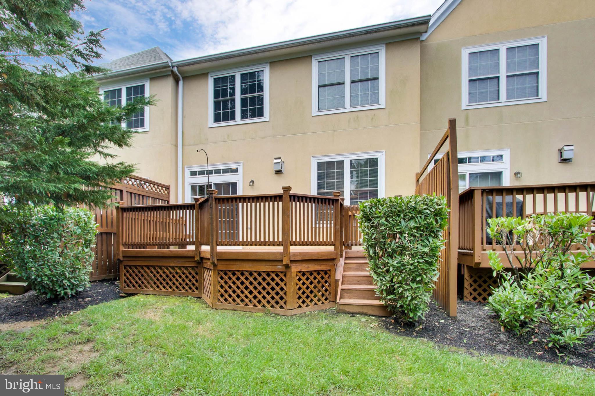 8818 Howard Forest Lane Baltimore, MD 21208 - Photo 30 of 31 a view of a house with wooden deck and a yard
