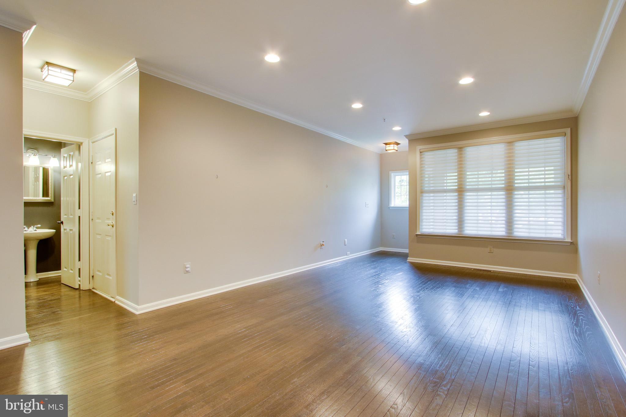8818 Howard Forest Lane Baltimore, MD 21208 - Photo 5 of 31 an empty room with wooden floor and windows