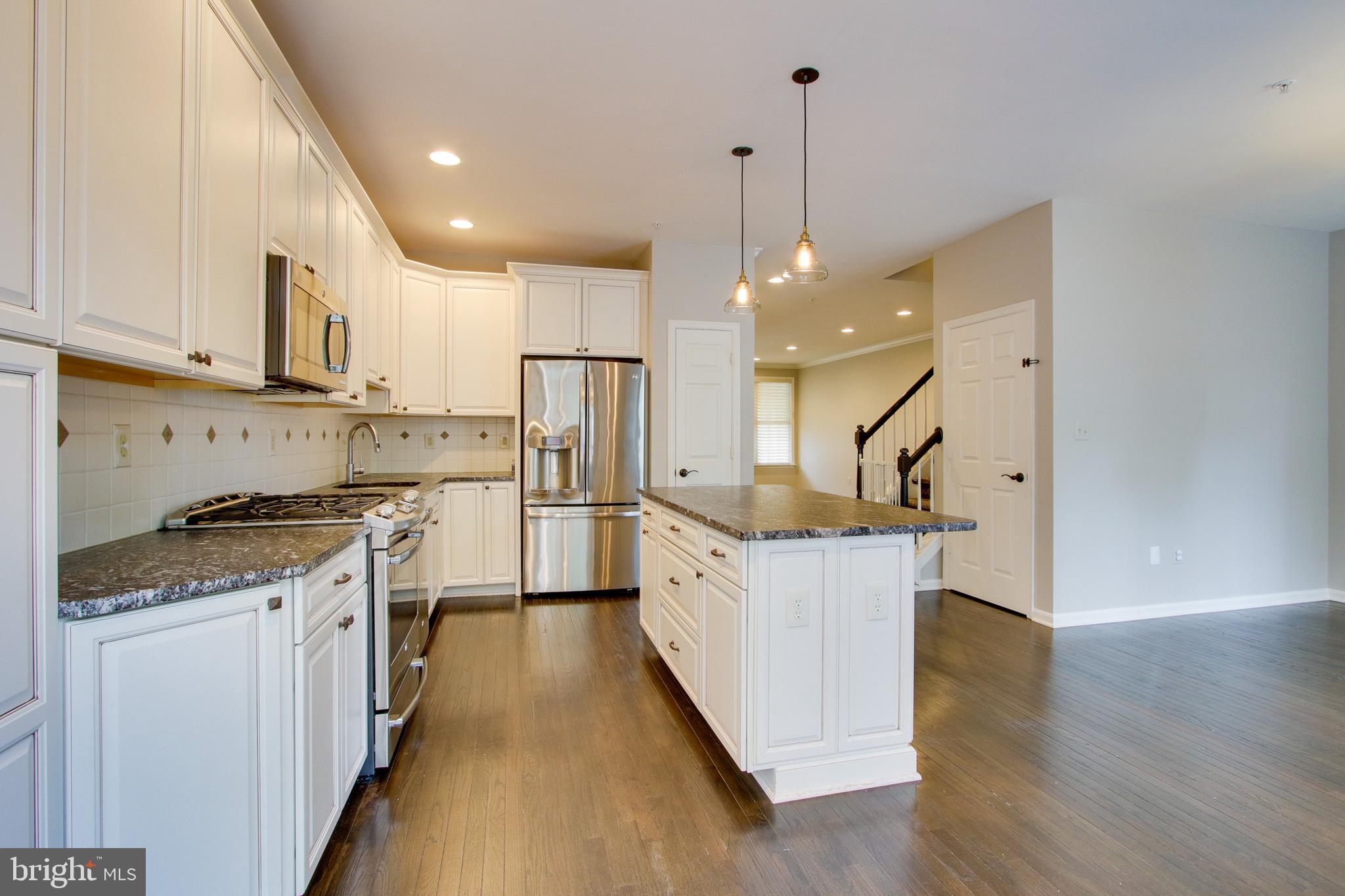 8818 Howard Forest Lane Baltimore, MD 21208 - Photo 10 of 31 a kitchen with stainless steel appliances granite countertop a sink a stove and a refrigerator