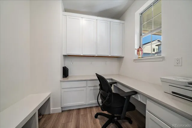 a view of a workspace with furniture and wooden floor