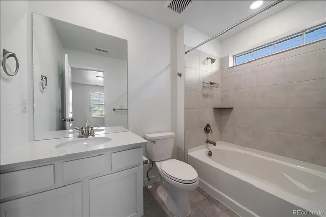 a bathroom with a toilet a sink a mirror a bathtub and vanity