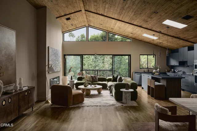 a living room with furniture a large window and a chandelier