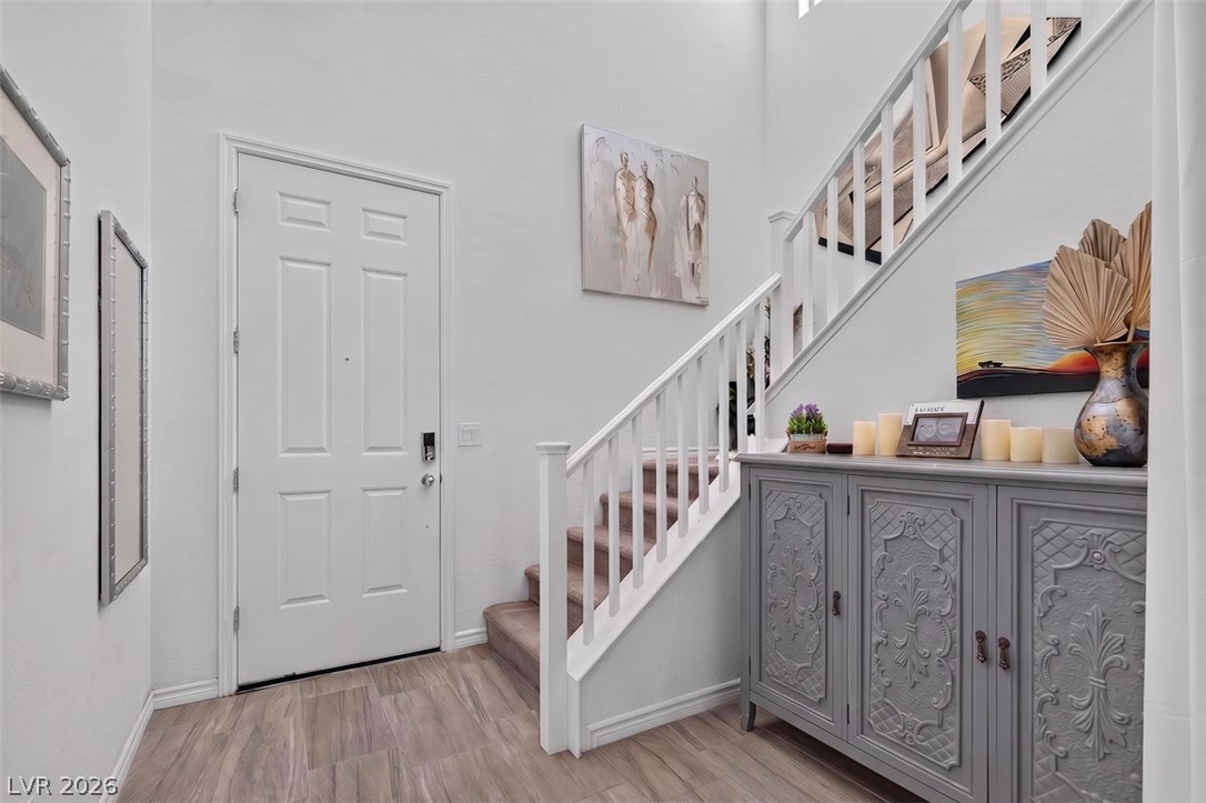 1824 Redland Ridge Street Henderson, NV 89002 - Photo 5 of 69 Enter into a welcoming foyer, featuring a contemporary door and inviting staircase.
