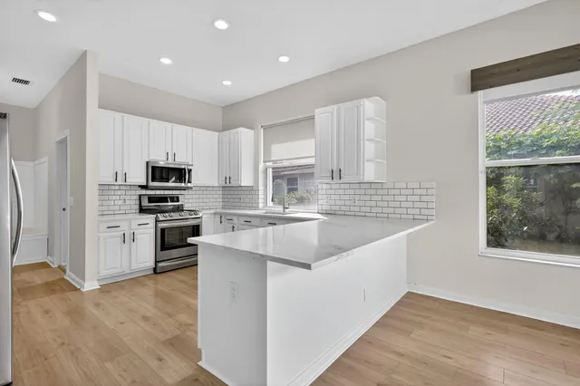 a kitchen with stainless steel appliances granite countertop a sink stove and refrigerator