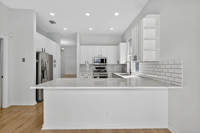 a kitchen with stainless steel appliances a refrigerator and a stove top oven