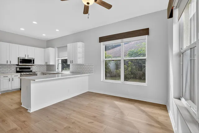 a large kitchen with stainless steel appliances granite countertop a stove a sink and a microwave