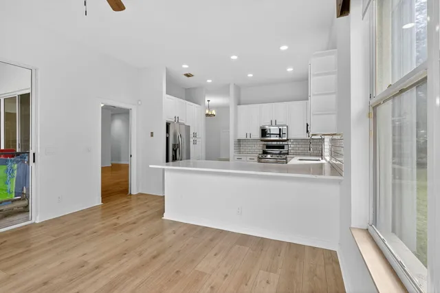 a view of kitchen with stainless steel appliances refrigerator stove microwave and cabinets