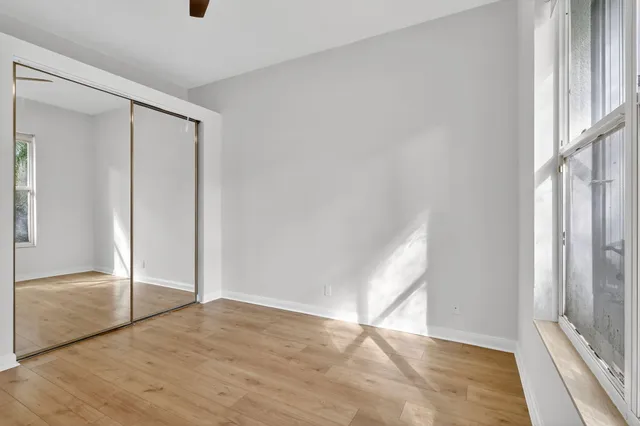 an empty room with wooden floor and a window