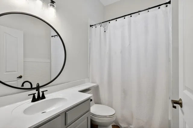 a bathroom with a sink vanity mirror and toilet