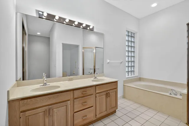 a bathroom with a granite countertop sink mirror and a bathtub
