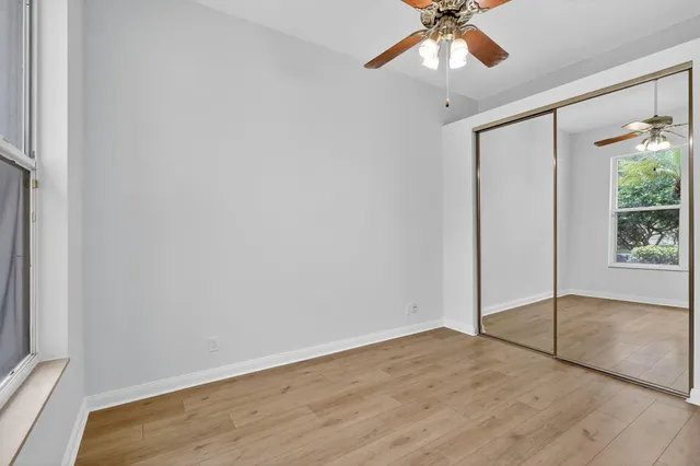 an empty room with fan and windows