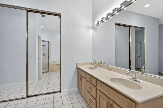 a bathroom with a double vanity sink mirror and shower