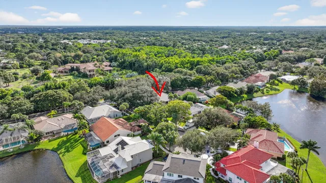 an aerial view of a house with a yard and lake view in back