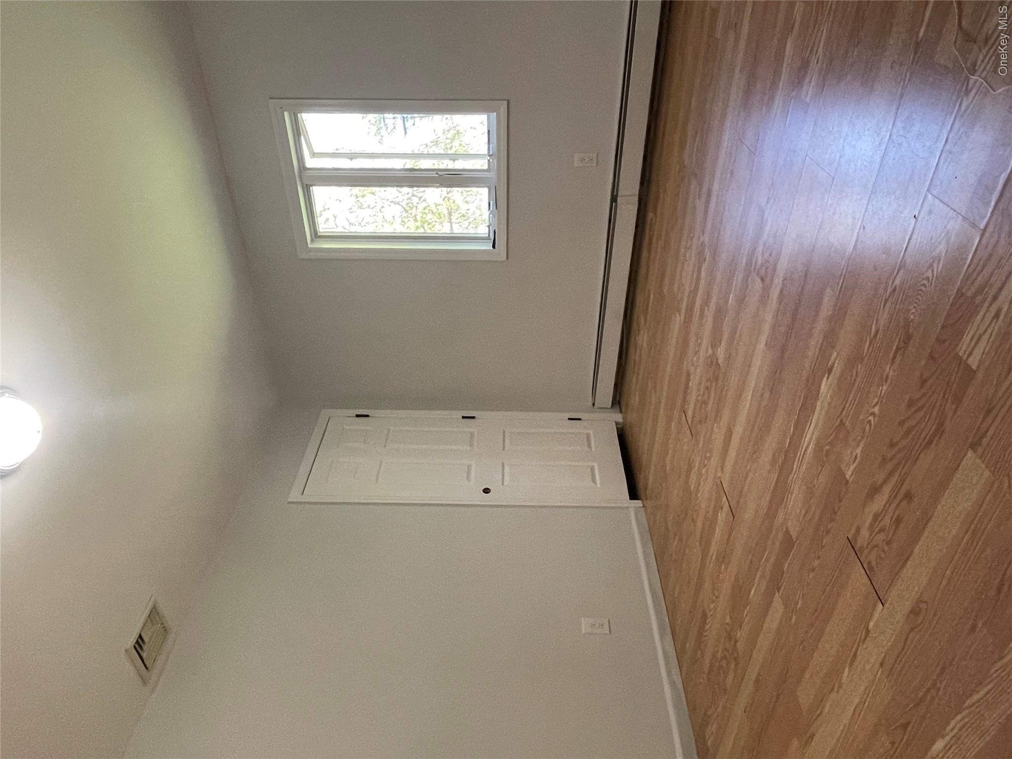 171 Hounslow Road Shirley, NY 11967 - Photo 14 of 31 wooden floor in an empty room with a window