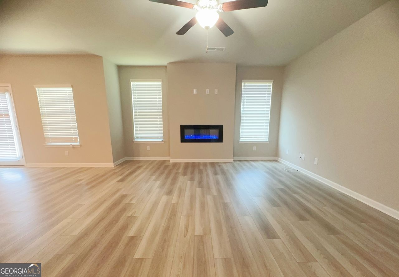 446 Sawmill Trace Hampton, GA 30228 - Photo 2 of 15 wooden floor in an empty room with a window