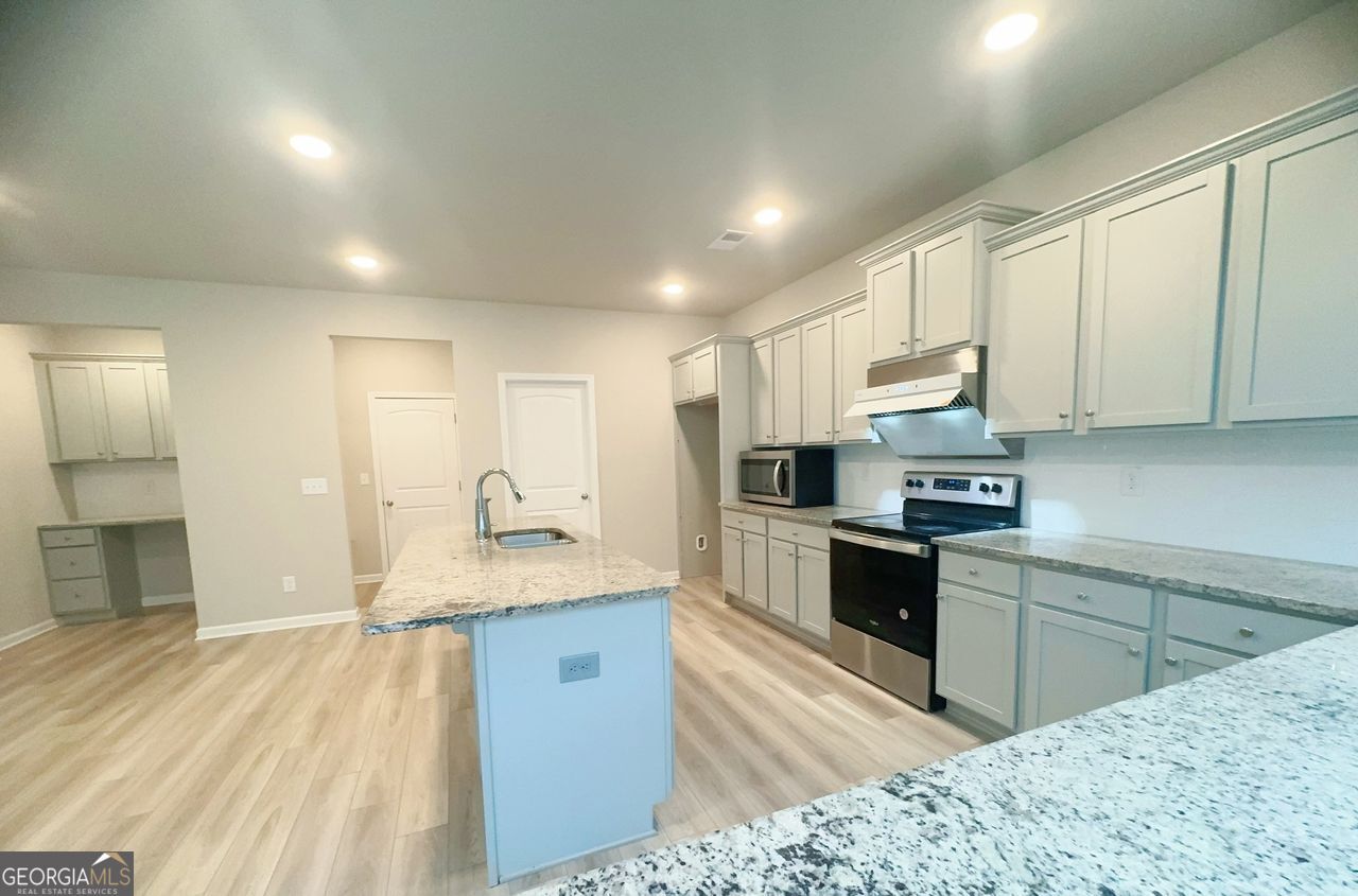 446 Sawmill Trace Hampton, GA 30228 - Photo 3 of 15 a kitchen with stainless steel appliances granite countertop a sink stove and refrigerator