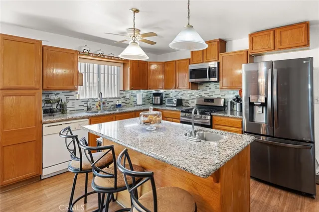 a kitchen with stainless steel appliances granite countertop a sink a refrigerator and a stove