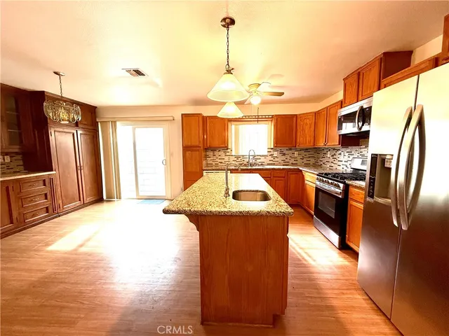 a kitchen with stainless steel appliances granite countertop a stove a sink and a microwave