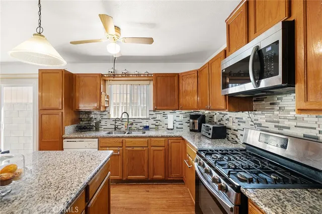 a kitchen with stainless steel appliances granite countertop a stove a sink and a microwave