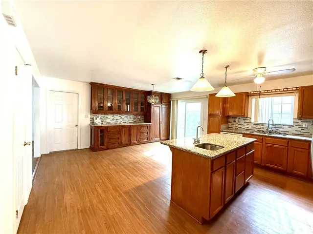 a view of a room with wooden floor and a ceiling fan