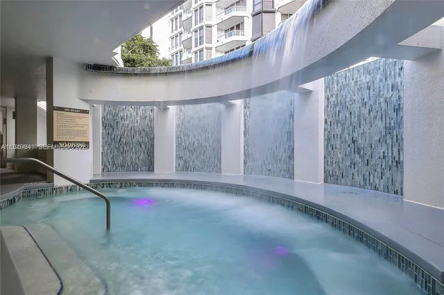 a dining room with furniture a large window and a kitchen view