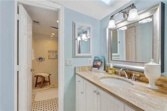 a bathroom with a granite countertop sink vanity and mirror