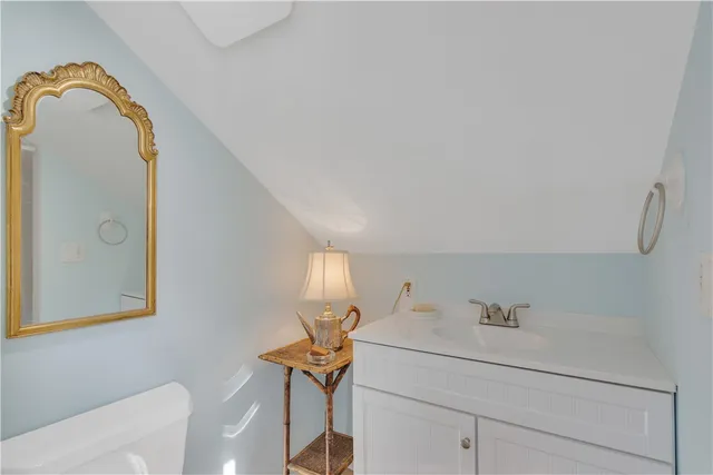 a bathroom with a sink and mirror with toilet