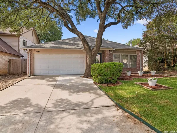 a front view of a house with a yard and trees