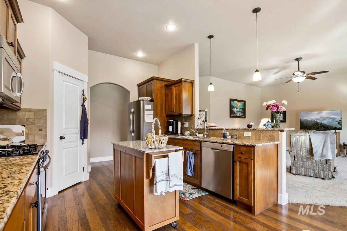 1213 West Lowry Street Meridian, ID 83646 - Photo 19 of 38 Kitchen with stainless steel appliances, pendant lighting, light stone countertops, arched walkways, and a peninsula