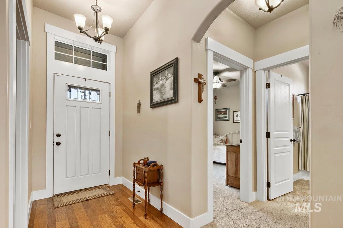 1213 West Lowry Street Meridian, ID 83646 - Photo 4 of 38 Foyer entrance featuring hanging lights, arched walkways, and light wood-style floors