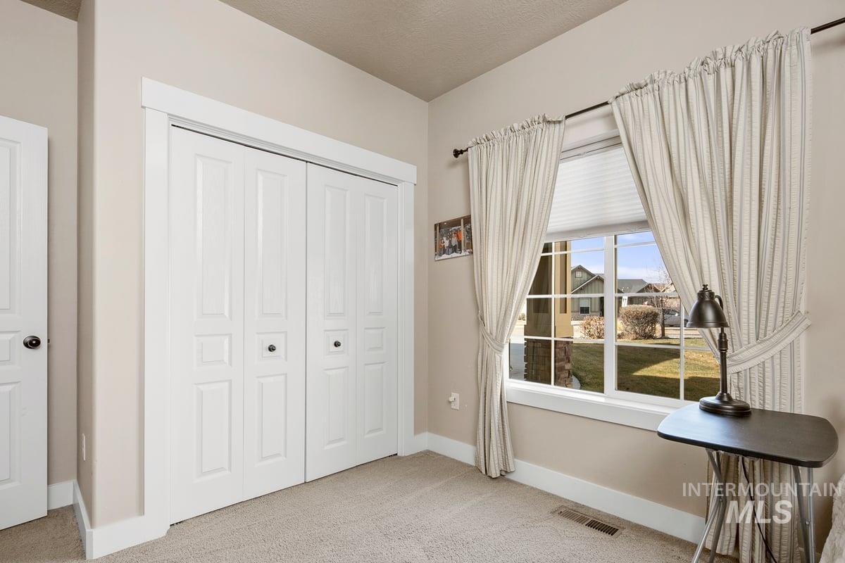 1213 West Lowry Street Meridian, ID 83646 - Photo 8 of 38 Bedroom with light carpet, a closet, and a textured ceiling