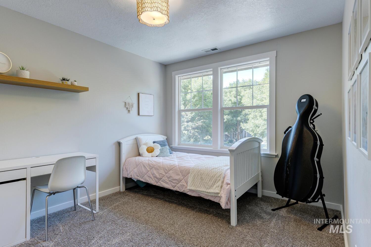 5572 West School Ridge Road Boise, ID 83714 - Photo 23 of 50 Bedroom featuring a desk, carpet floors, and a textured ceiling