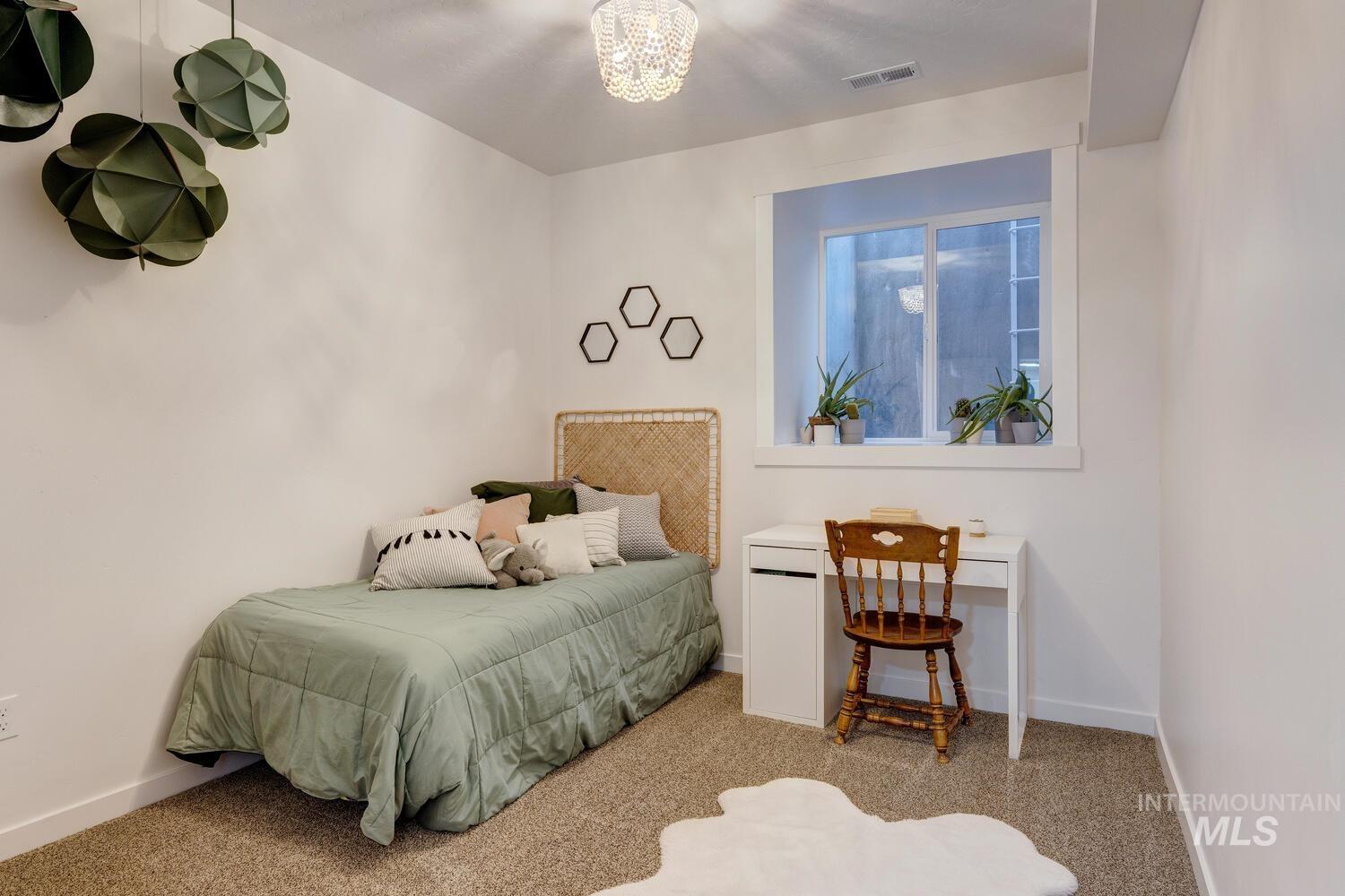 5572 West School Ridge Road Boise, ID 83714 - Photo 32 of 50 Carpeted bedroom with baseboards and a chandelier